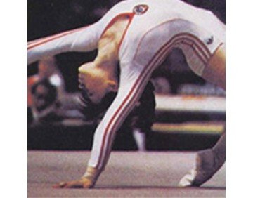 Enfant effectuant une figure de gymnastique au sol, démontrant souplesse et équilibre physique.