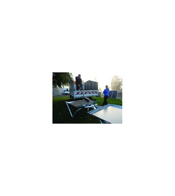 Personnes déployant une table ping pong pliable extérieur sur un terrain, avec matériel et camion en arrière-plan.