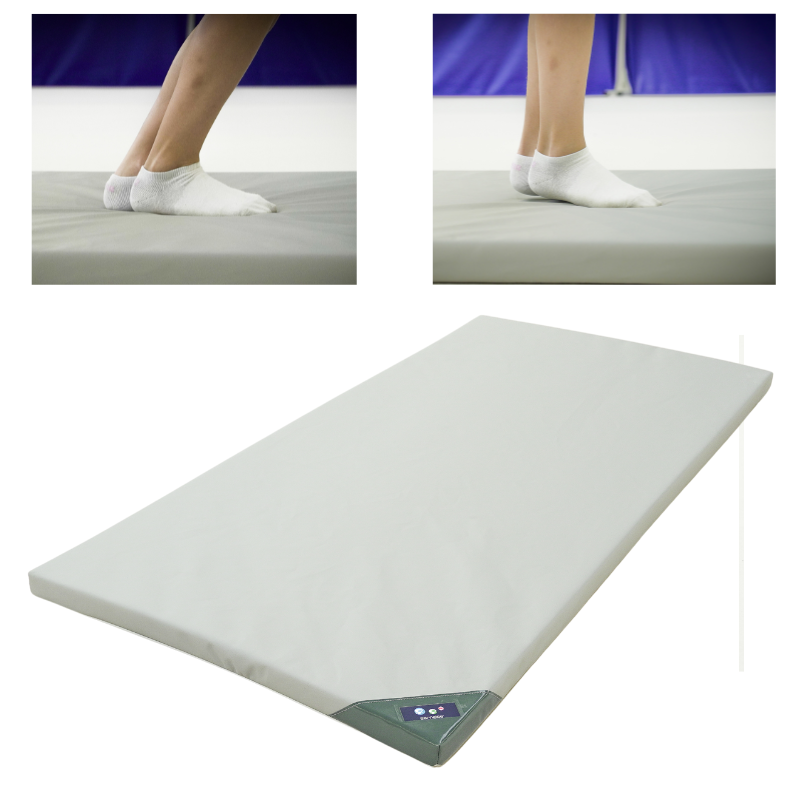 Surface d骤entraînement pliable avec revêtement léger et images des pieds en chaussettes sur un tapis de gym blanc.