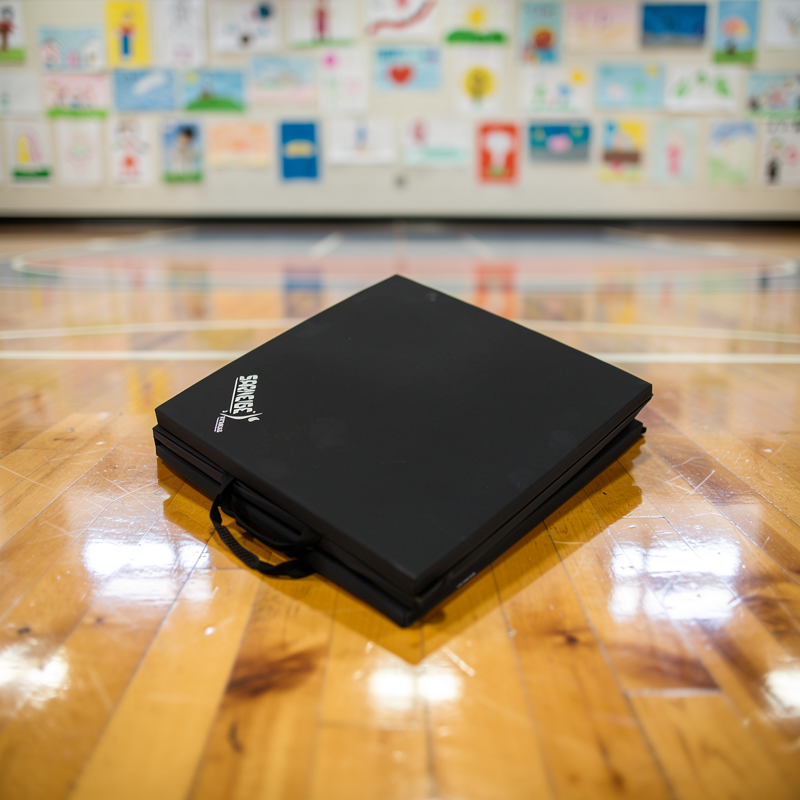 Tapis de gymnastique plié noir dans un gymnase scolaire prêt pour le cours d'EPS
