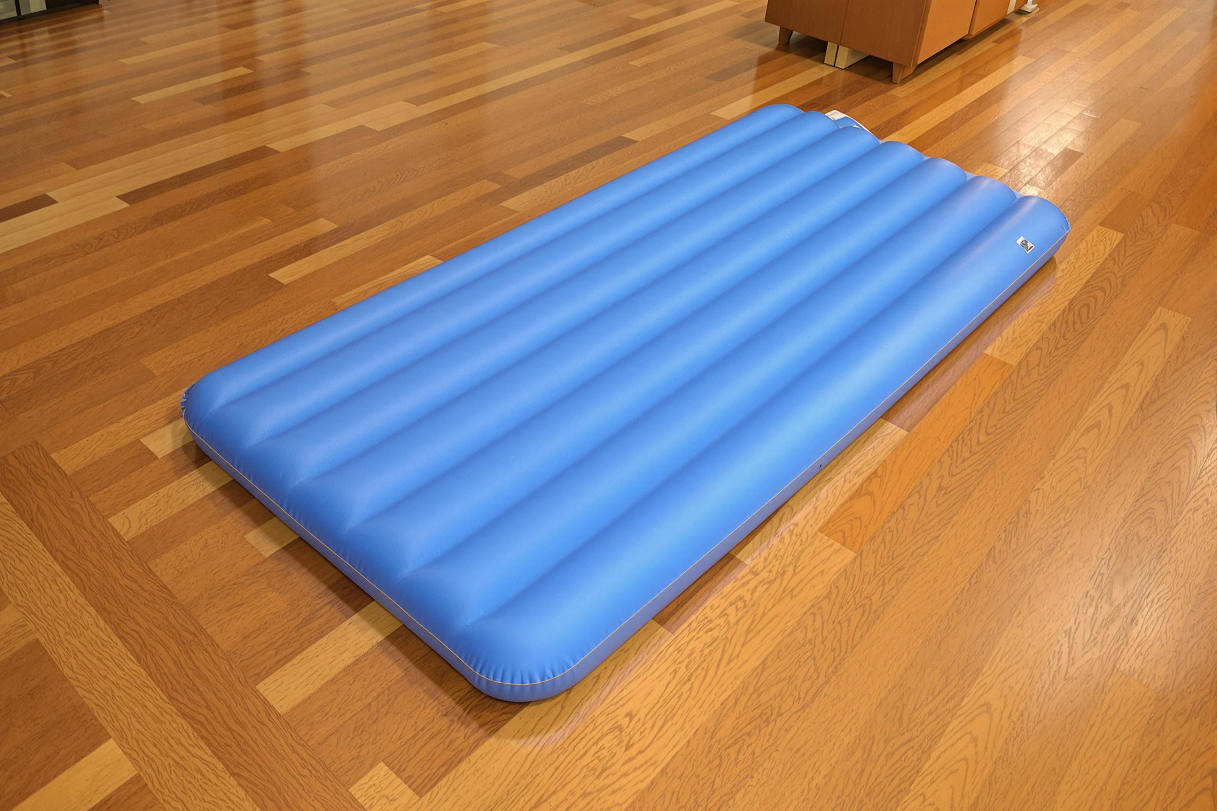 Tapis de gym gonflable posé sur un sol en bois