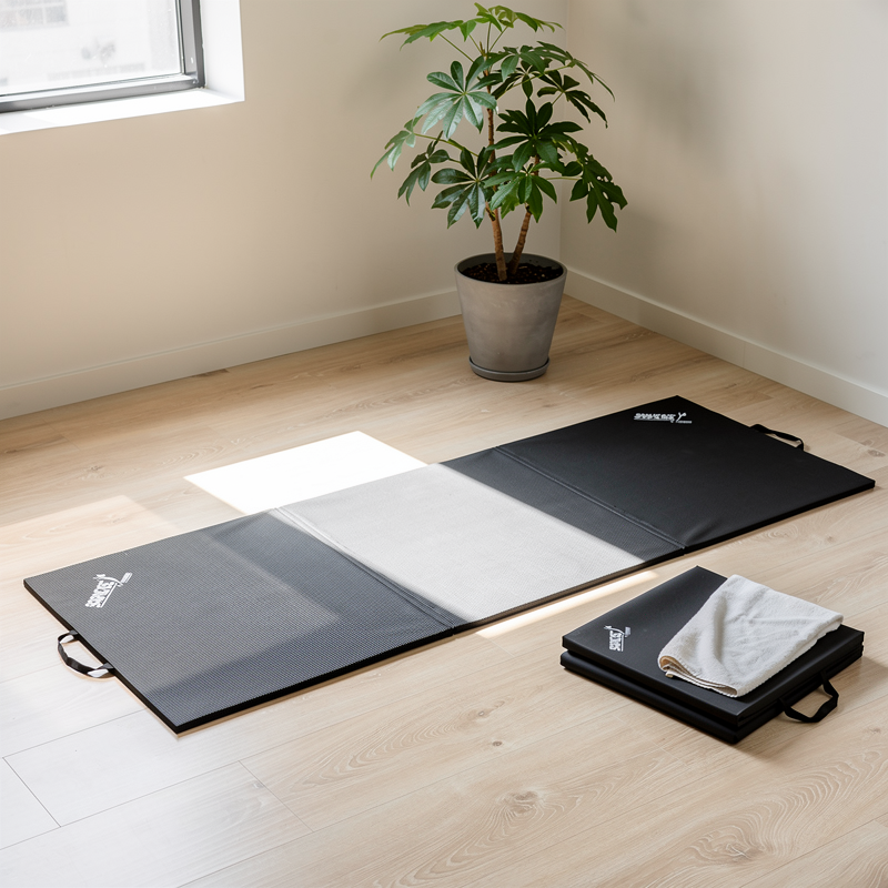 Tapis de gym pliable noir installé dans un coin yoga lumineux à la maison